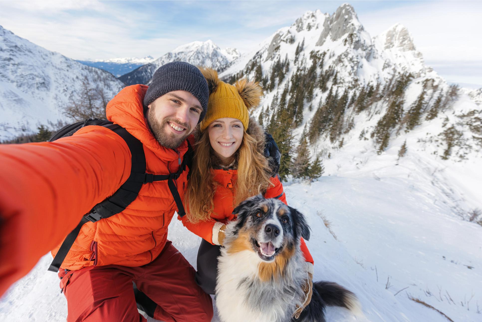 Dog hiking with owners in the snow.